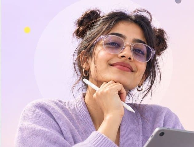 Marketing professional with glasses holding a stylus and tablet